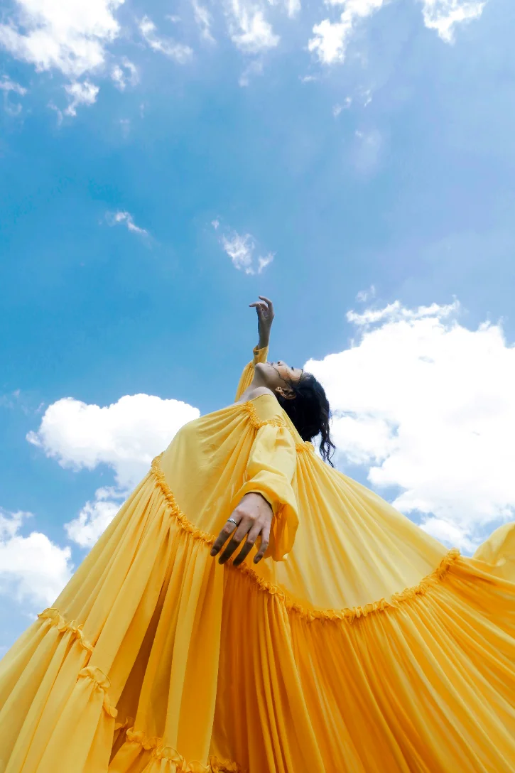 Vestido amarelo em movimento contra o céu